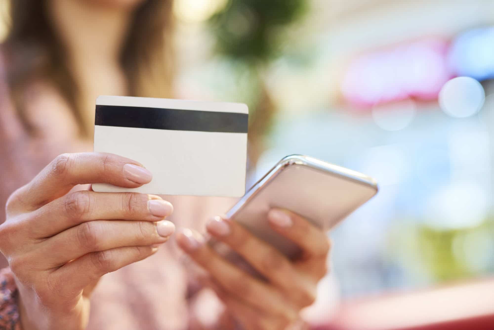 woman using mobile phone credit card during online shopping
